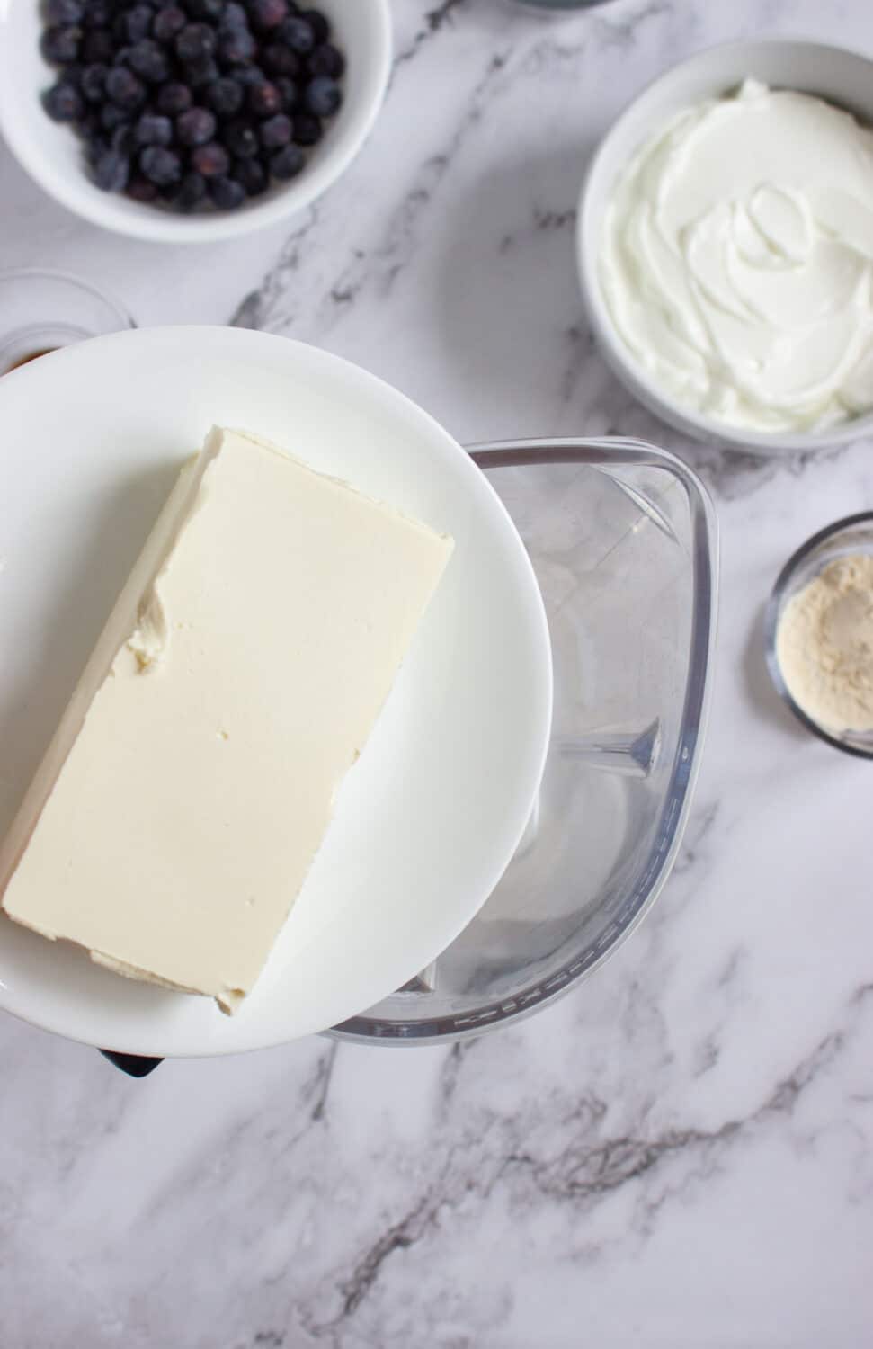adding cream cheese to a blender