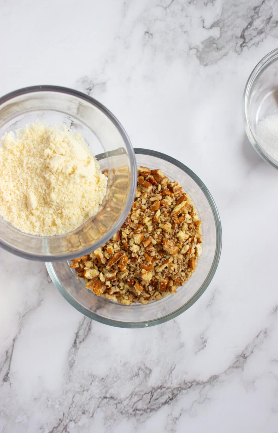 adding almond flour to chopped pecans