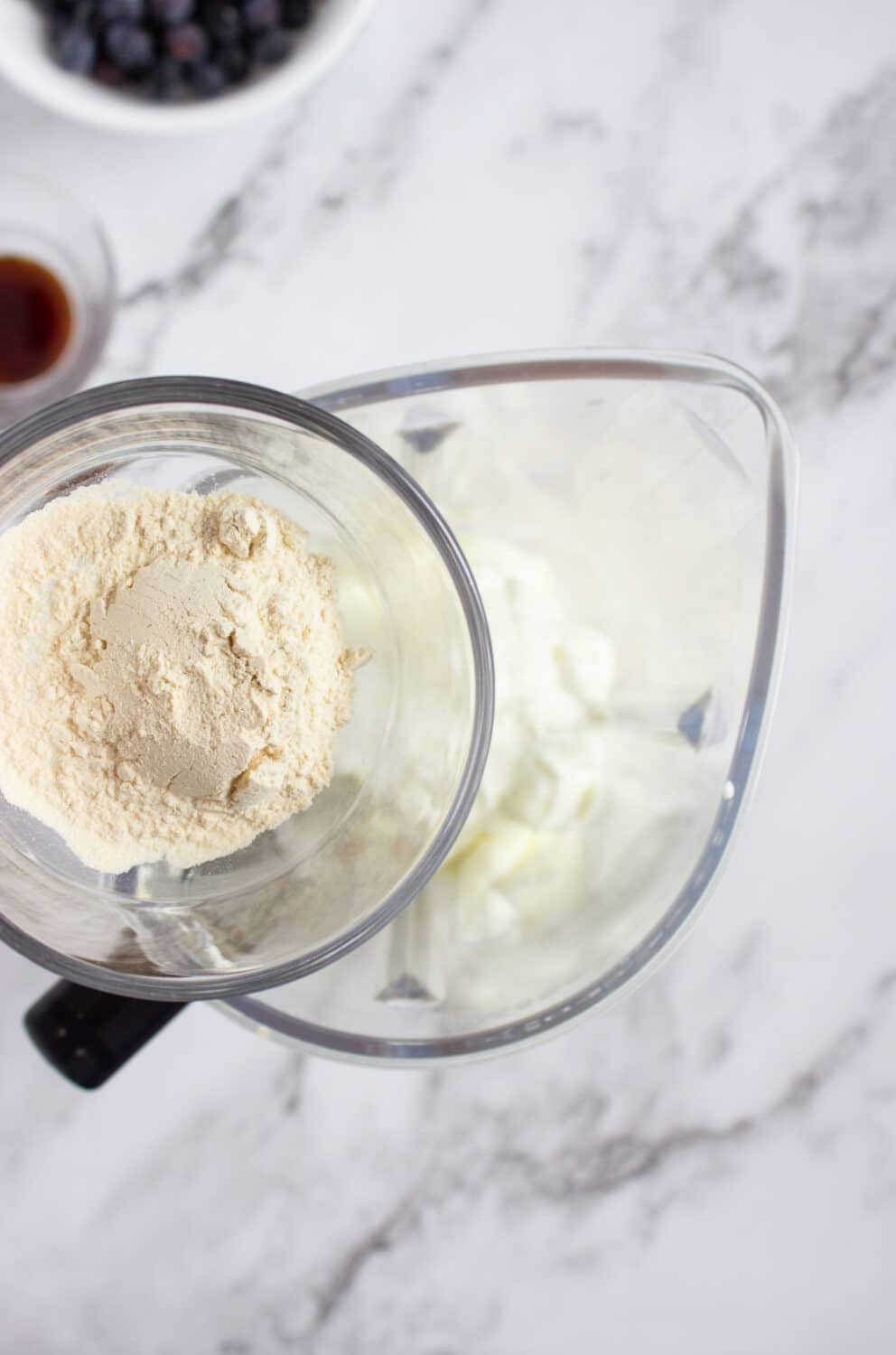 adding protein powder to a blender