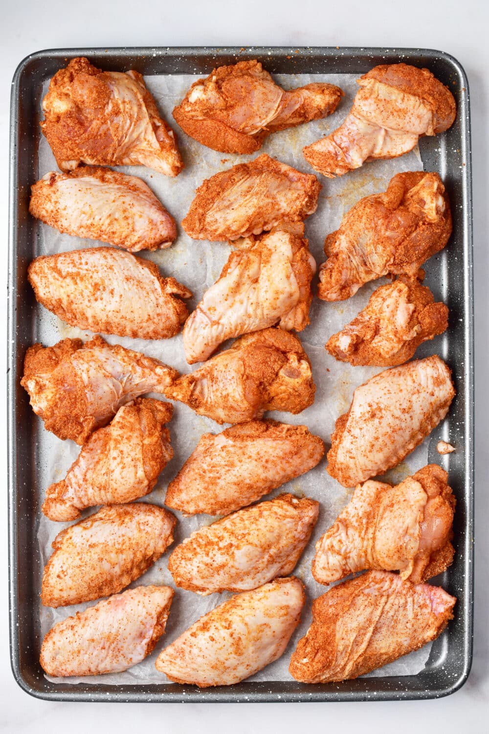 coated chicken wings on a baking pan