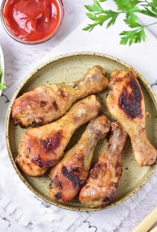 Baked Honey Mustard Chicken Drumsticks overhead view with ketchup and garnish