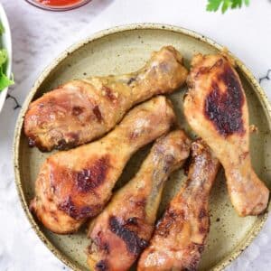 Baked Honey Mustard Chicken Drumsticks overhead view with ketchup and garnish