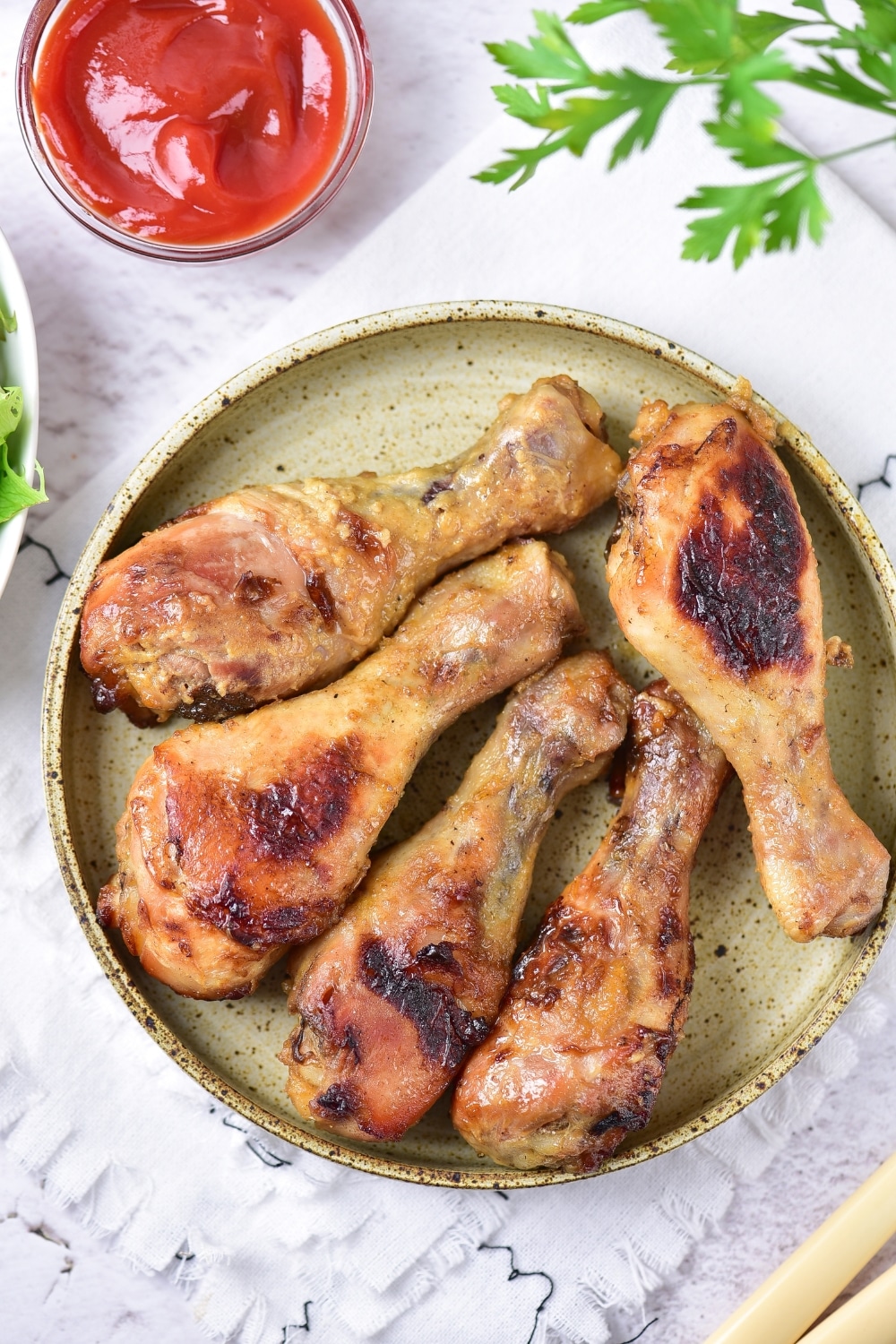 Baked Honey Mustard Chicken Drumsticks overhead view with ketchup and garnish