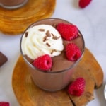Chocolate Peanut Butter Cottage Cheese Pudding on a wooden board with raspberries