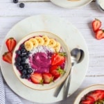 overhead view High Protein Berry Smoothie Bowl with two spoons with strawberries and bananas