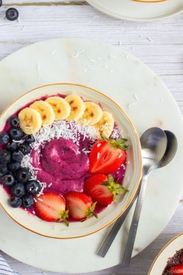 overhead view High Protein Berry Smoothie Bowl with two spoons with strawberries and bananas