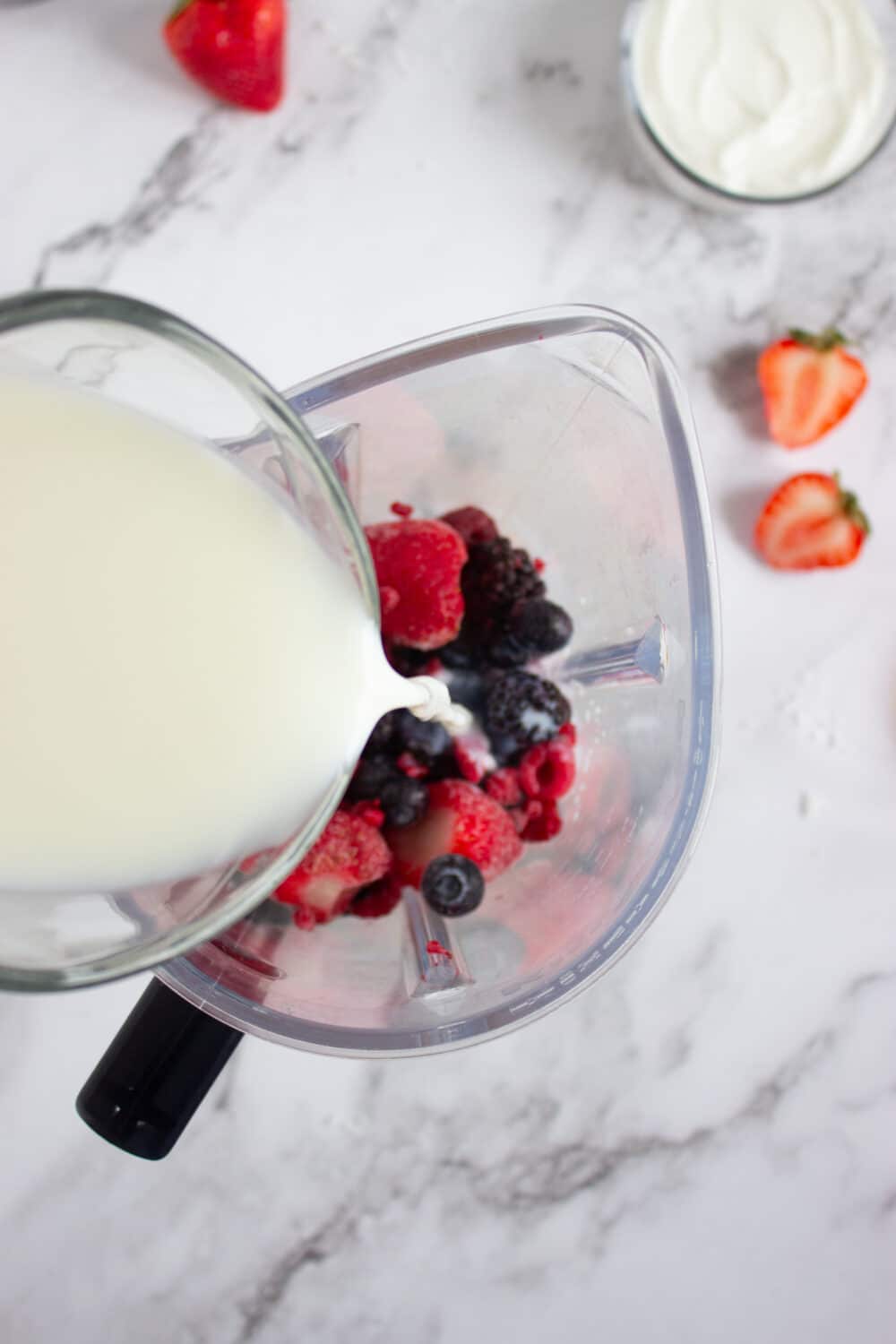 adding milk to a blender