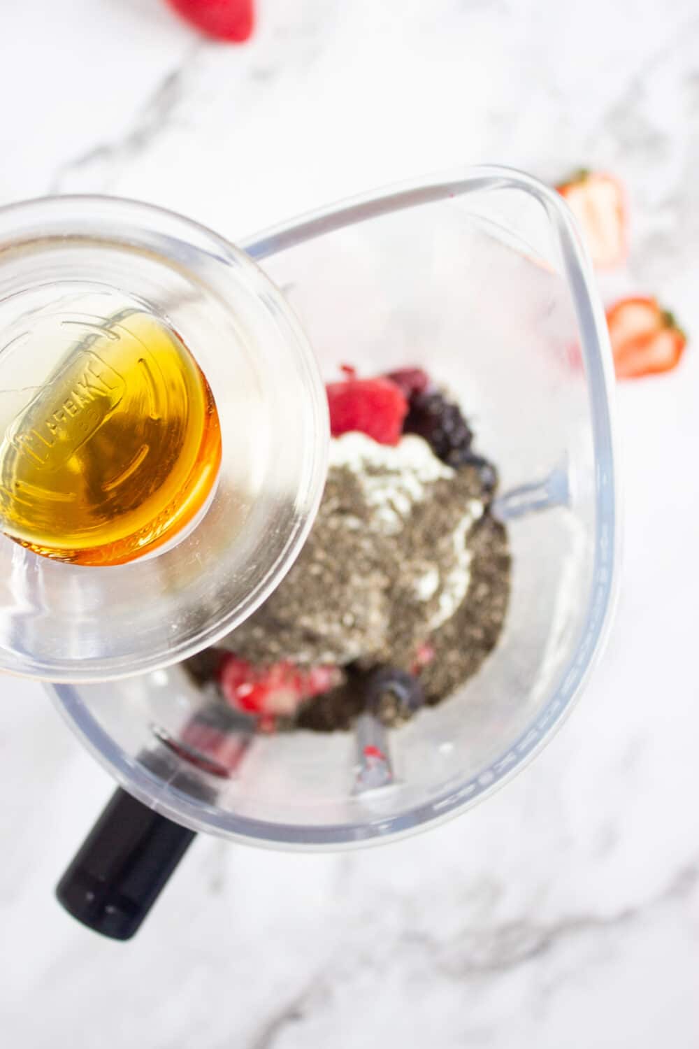 adding maple syrup to a blender