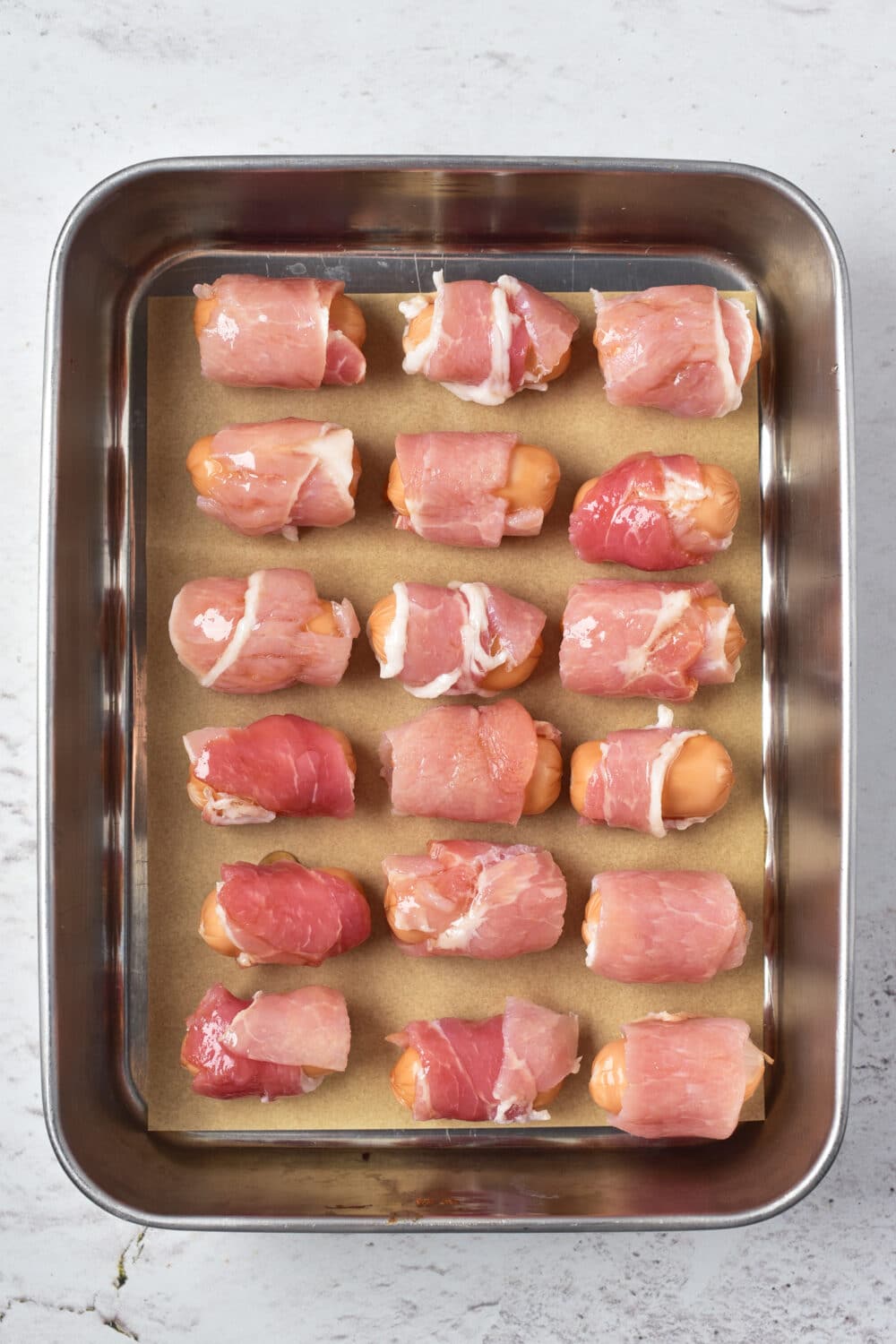 pigs in a blanket ready for oven on baking sheet, overhead view