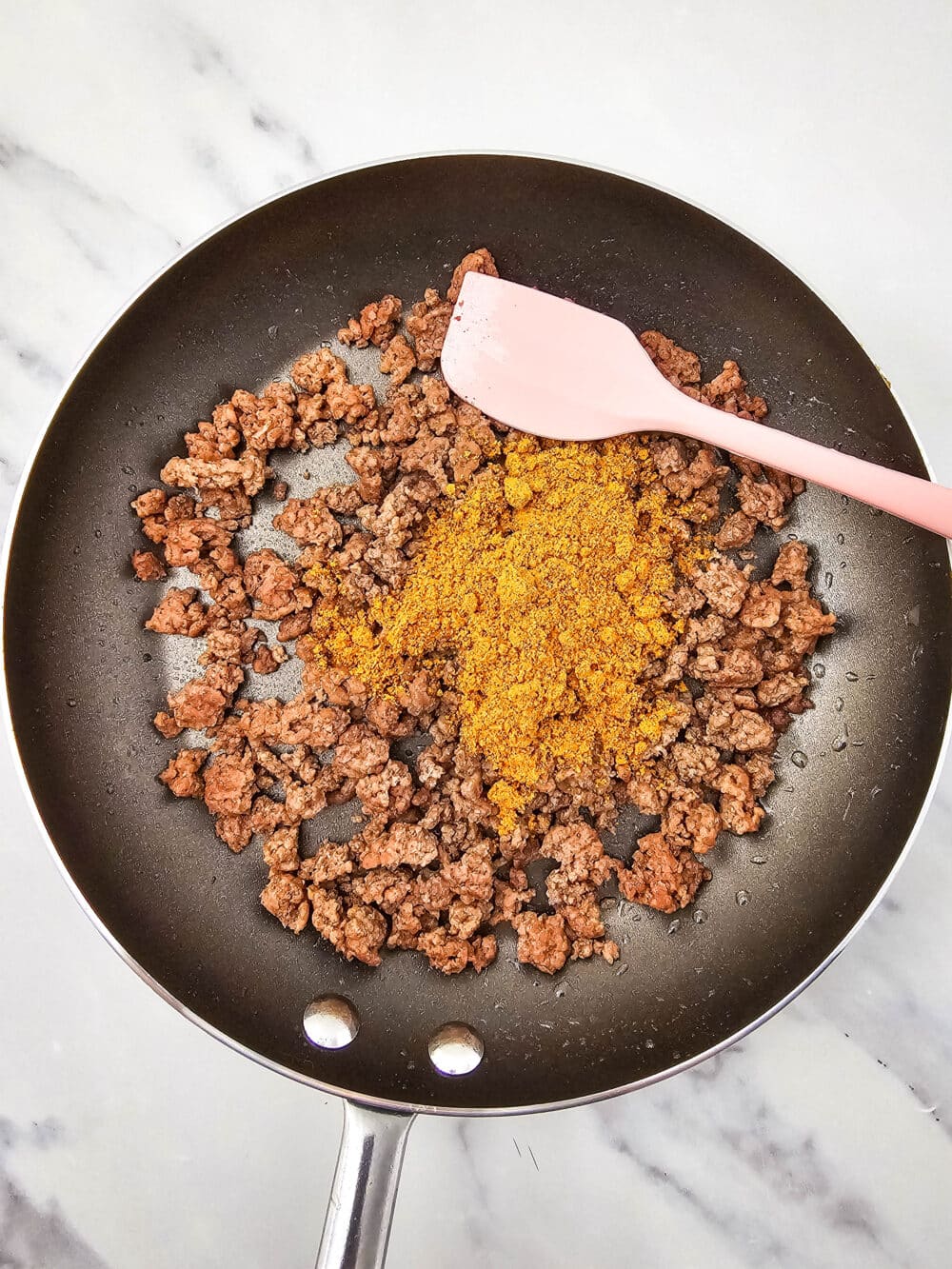 browned meat with taco seasoning in a skillet