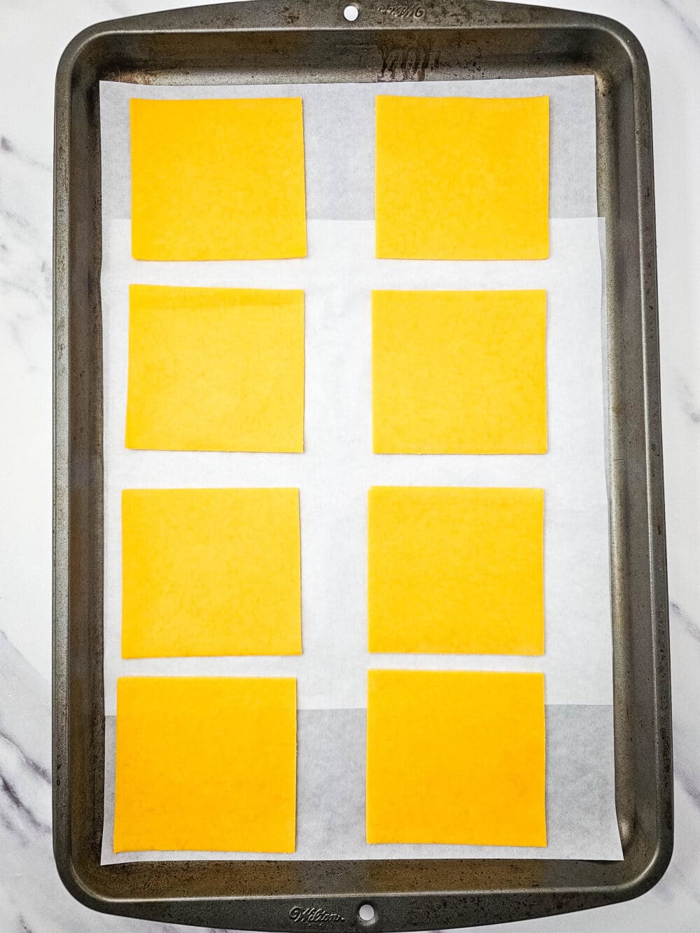 slices of cheese on a baking sheet ready to be baked