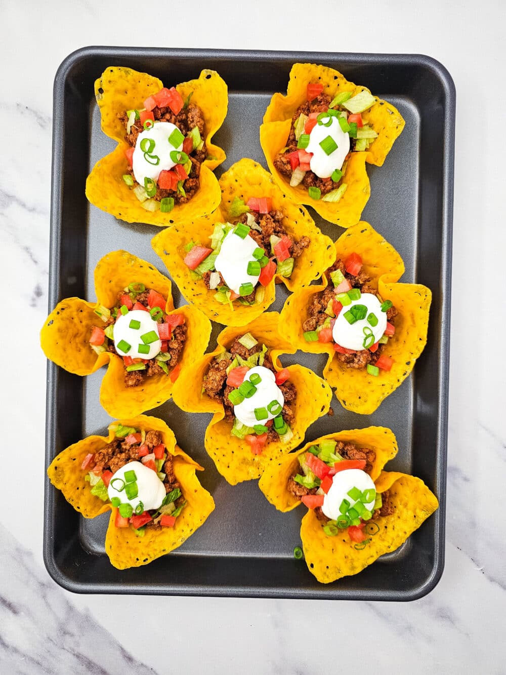 baked cheese fitted into muffin tin with seasoned ground beef and toppings added