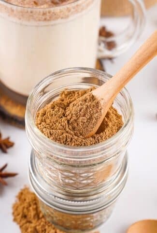 close-up of chai spice mix in a jar with spoon for scooping