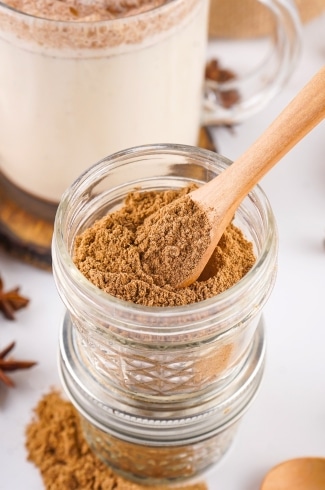 close-up of chai spice mix in a jar with spoon for scooping
