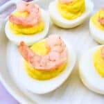 Plate of shrimp deviled eggs, each topped with a small shrimp, ready to serve.