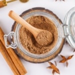 close-up of chai spice mix in a jar with spoon for scooping