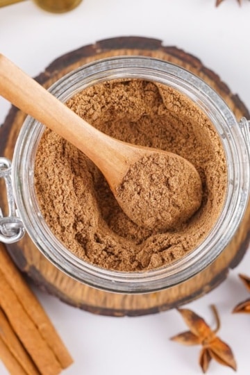 close-up of chai spice mix in a jar with spoon for scooping