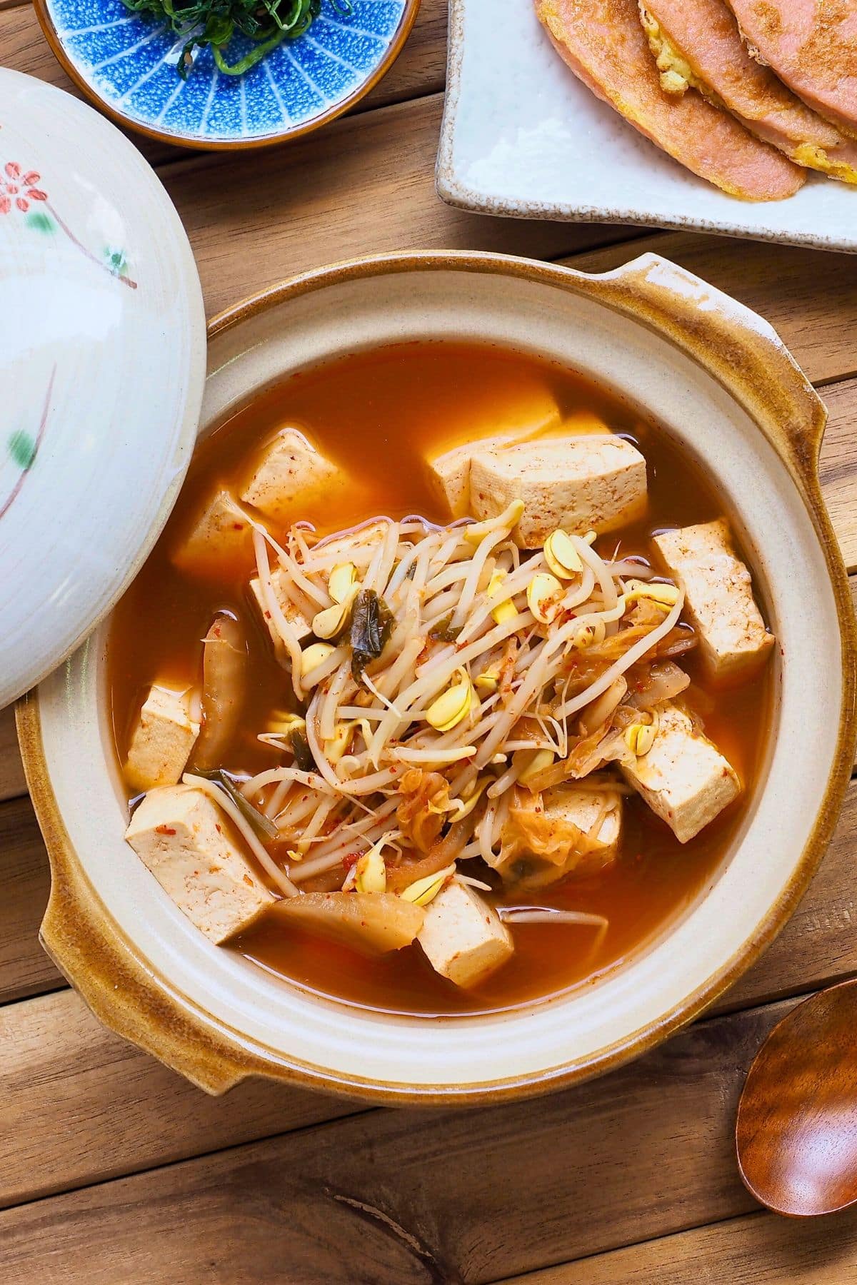 Korean bean sprout soup with tofu and vegetables in a white bowl