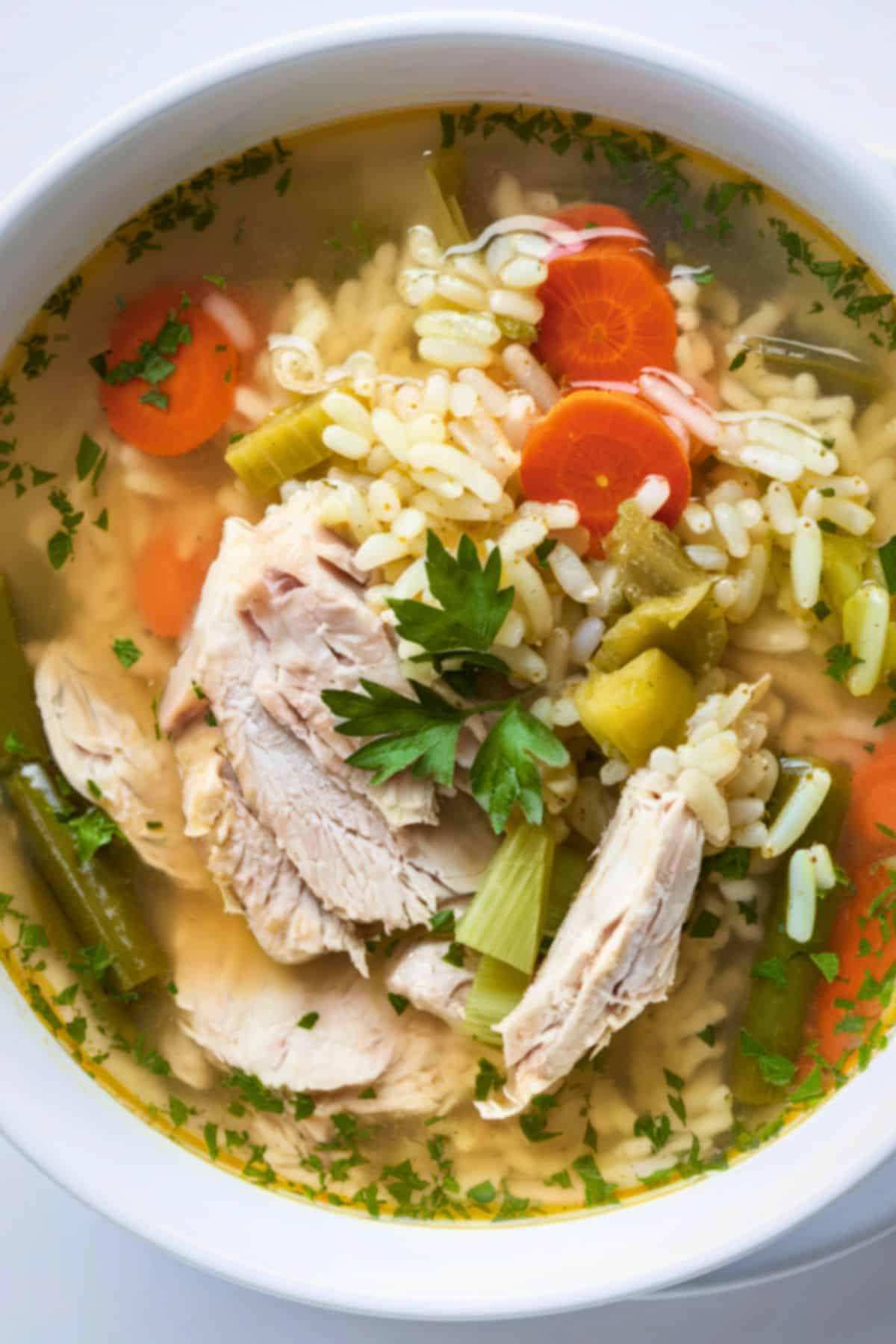 Bone broth chicken soup with rice, carrots, and fresh herbs