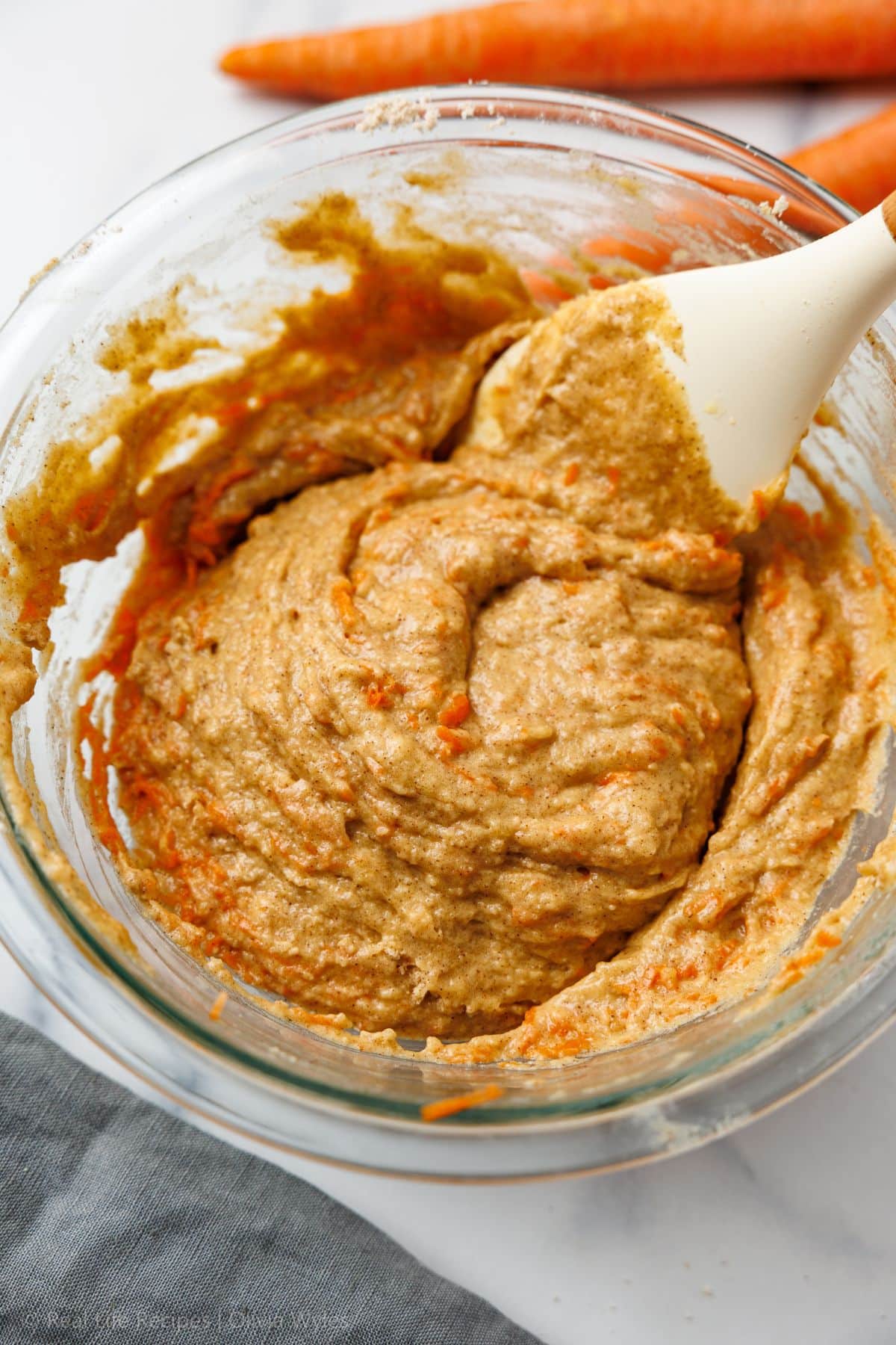 Carrot cake batter with finely grated carrots fully folded in, smooth and ready to scoop