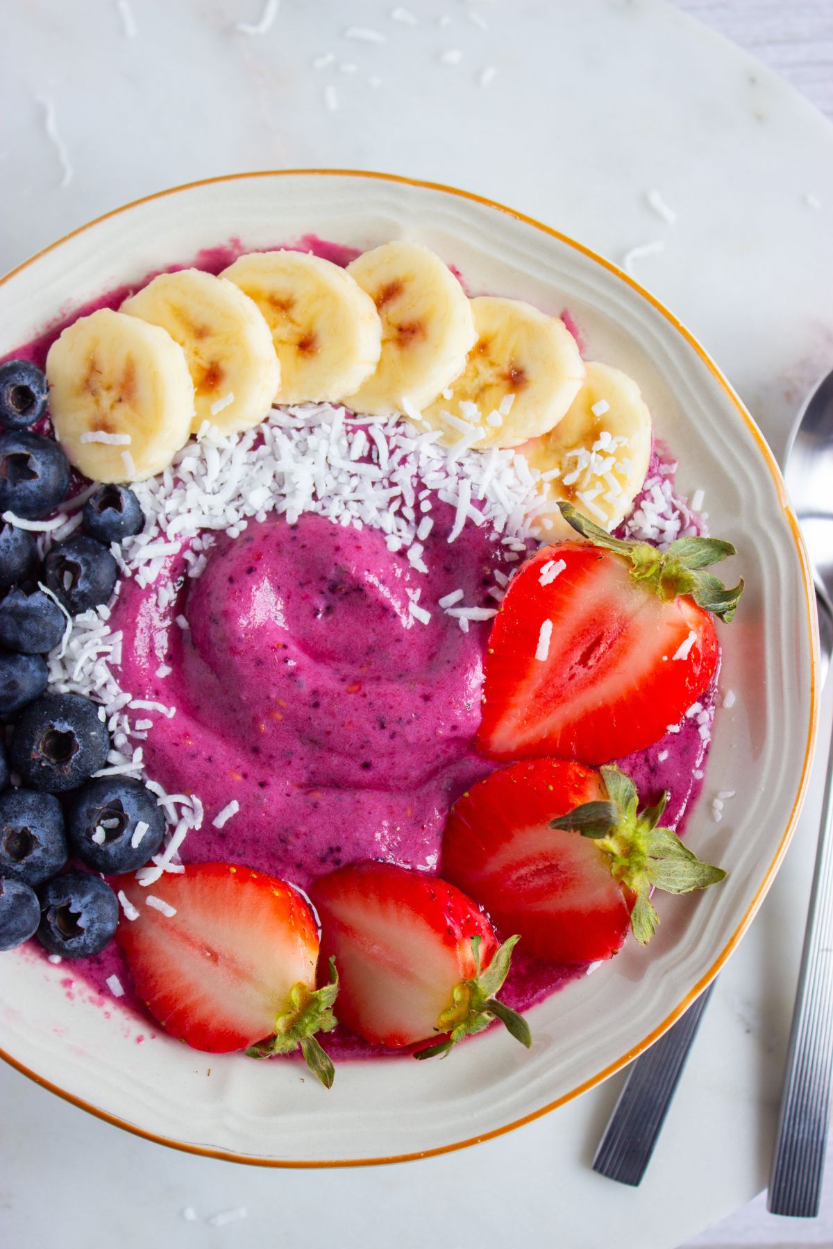 Berry smoothie bowl topped with fresh fruit