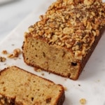 Close-up of a sliced gluten free banana bread loaf on a board, showing the cut end and soft crumb texture.