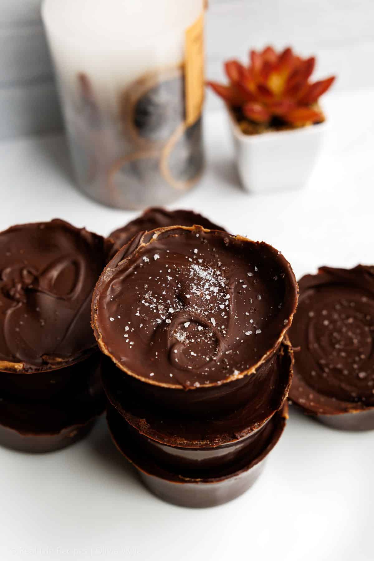 Side view of stacked keto big peanut butter cups with sea salt on top.