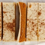 Close-up square crop of sliced pumpkin protein bars, one turned to reveal the pumpkin interior