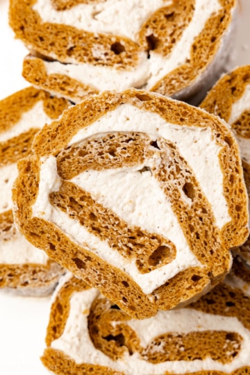 Stacked slices of gluten-free sugar-free pumpkin roll showing the spiral of cake and cream cheese filling.